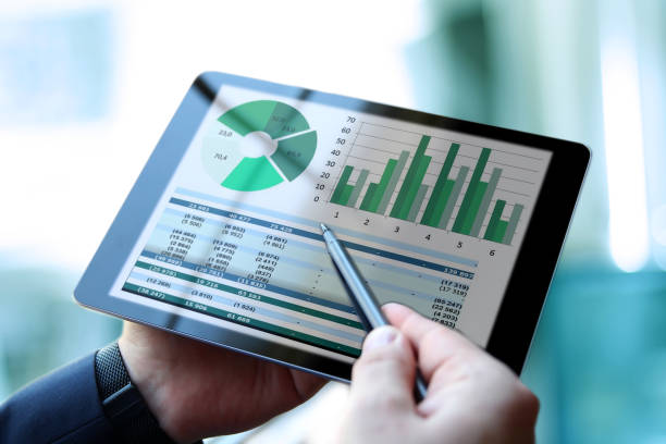 Business man working and analyzing financial figures on a graphs using a tablet